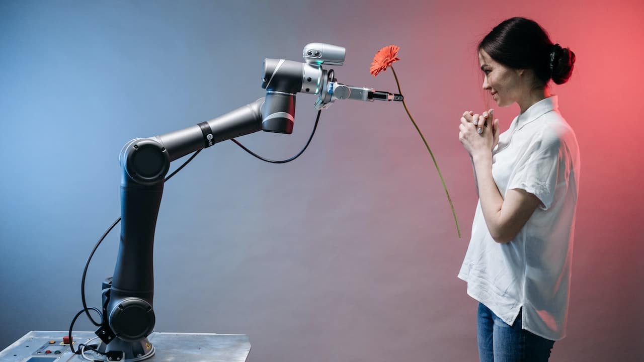 Intelligenza artificiale e sostenibilità: un braccio robotico dona un fiore a una donna