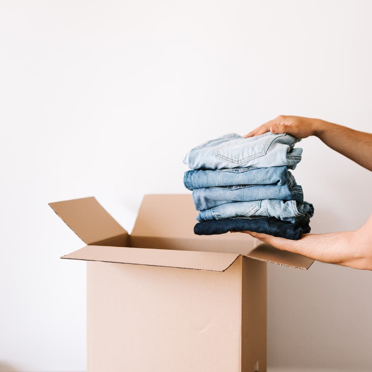 Riciclo dei tessuti: Vecchi jeans vengono impilati in una scatola prima di passare a seconda vita