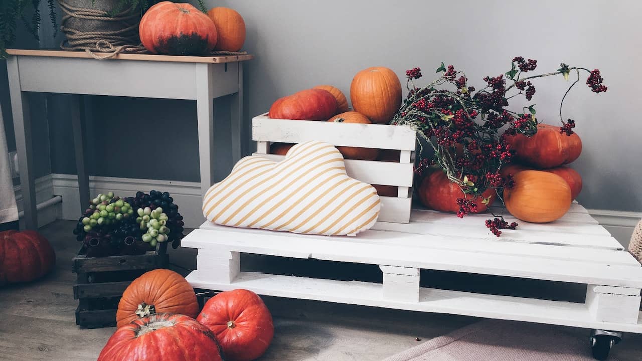 Elementi di arredo in pallet design per la cucina, su essi sono appoggiate delle zucche.