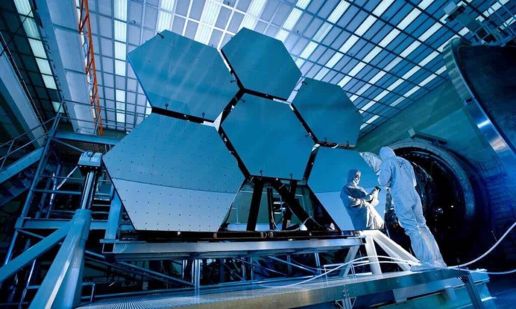 Tecnici assemblano specchi di un grande telescopio.