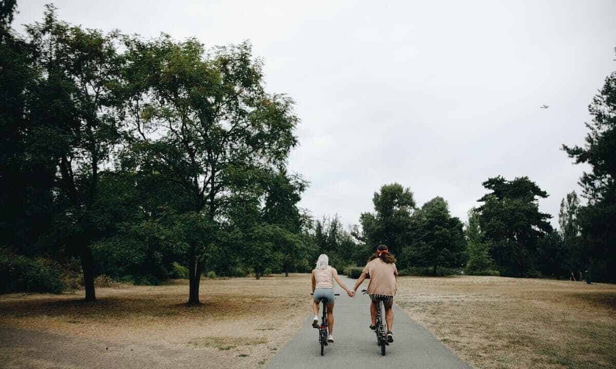 Piste ciclabili con pannelli solari: due ciclisti pedalano mano nella mano