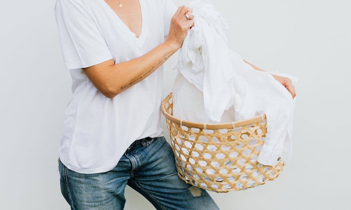 Bucato ecologico: una donna svuota il cesto della biancheria