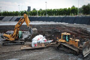 Escavatore e bulldozer rimuovono amianto a Torino.