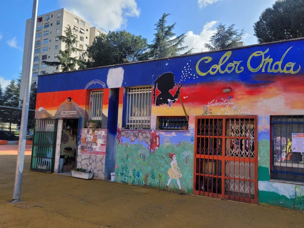 Edificio colorato con murales, insegna "Color Onde