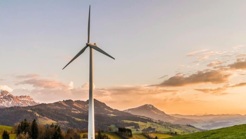 Turbina eolica in paesaggio montuoso al tramonto