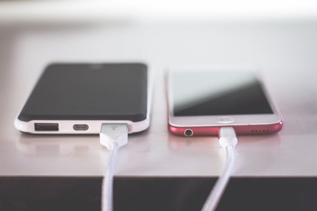 Smartphone e power bank in carica su un tavolo.