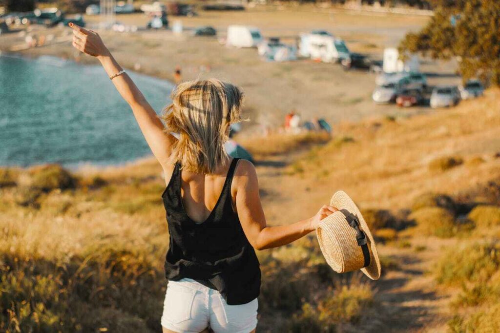 Dopo-sole naturali: una donna al sole con un cappello di paglia in mano