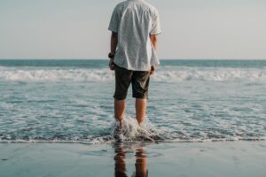 Dopo-sole naturali: un uomo con i piedi in acqua al mare