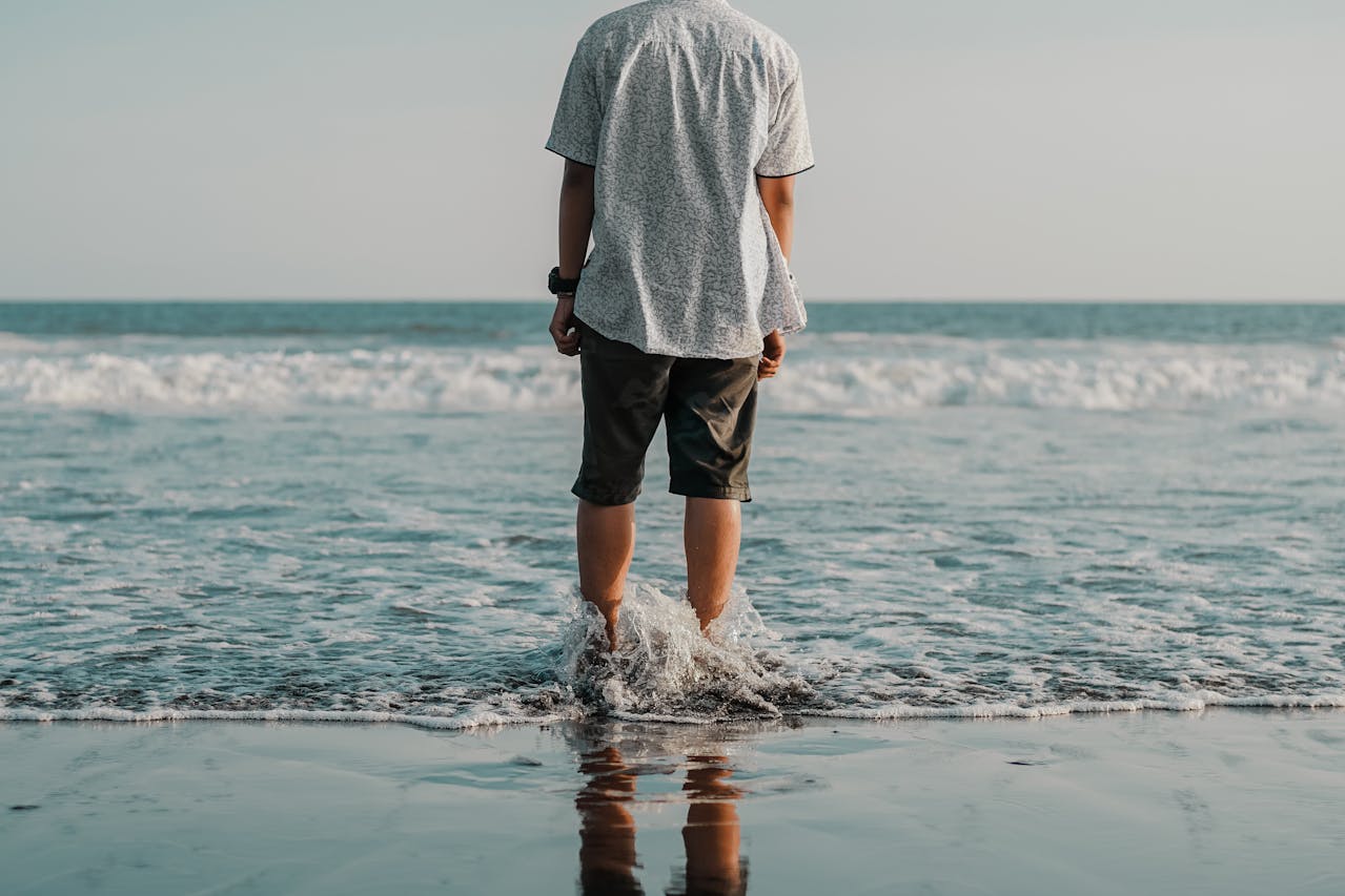 Dopo-sole naturali: un uomo con i piedi in acqua al mare